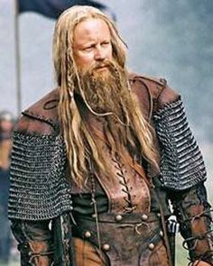 a man with long hair and beard wearing armor