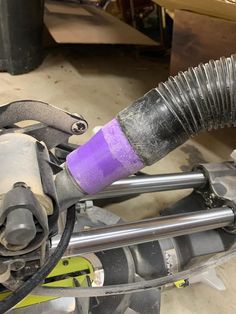 the front end of a vehicle with a purple hose attached to it's exhaust system