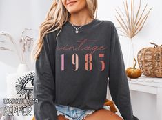 Classic 1985 Shirts For Women, Vintage 40th Birthday Year Number Tshirt For Him, 40th Milestone Best Friend Bday Gift For Her, 40 Bday Shirt HOW TO ORDER ➀ Select color ➁ Select the size (Please check size chart) ➂ Add to cart ✦ (Optional) "Add message to Seller" on the checkout page. GARMENT FEATURES ✦ Crew neckline ✦ Direct to garment printing - no vinyl, decal, or iron-on technique ✦ Our designs are printed on the garment to last a long time and may not appear as 'glossy' or saturated as iron-on designs are. ✦ Please note that colors may appear different on different digital screens and may not be a true representation of the actual colors. ✦ Additional T-Shirt Colors and Sizes Available Upon Request ✧✧Brands: Bella Canvas Unisex 3501 ✦ Long Sleeve Tee ✦ Solid colors: 100% cotton ✦ Heat The 1975 Shirt, 1984 Shirt, Bday Shirt, Milestone Birthday Gifts, Bday Gift, Shirts For Women, Women Vintage, 40th Birthday, Crew Neckline