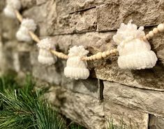 some white pom poms hanging from a stone wall