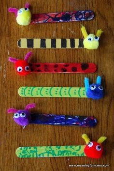 four different colored toothbrushes with faces on them sitting on top of a wooden table