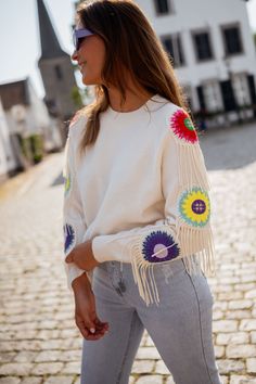 This cozy-chic ecru sweater boasts of a crewneck design, showcasing colorful embroidered flowers and delicate fringe detailing on the long sleeves. Our models are also wearing the Blue Maddie Jeans and the Light Blue Hunter Jeans One size (fits from US sizes 2-10) Length 22.0 in - Width 19.3 in 42% Acrylic - 30% Polyamide - 28% Polyester Washing: Handwash only Spring Bohemian Sweater With Tassels, Spring Long Sleeve Sweater With Tassels, Spring Long Sleeve Sweater With Fringe, Spring Fringe Long Sleeve Sweater, Spring Long Sleeve Fringe Sweater, Beige Fringe Casual Sweater, Crewneck Design, White Crewneck, Cozy Chic