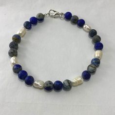 "🌸 Sign up for the Starfish by Kristan email list and get 15% off your order NOW! https://mailchi.mp/13833f6189a3/new-customers 🌸 Looking for high quality, affordable jewelry?  If so, this bracelet is for you!  This gorgeous lapis lazuli and freshwater pearl bracelet is perfect in any setting!  Each bead in this bracelet is hand selected and strung with high quality tarnish free silver beading wire to ensure the best quality. Lapis lazuli has been associated with strength and courage, royalty and wisdom, intellect and truth.  Hypoallergenic.   OUR BRACELETS ARE... *Made with high quality lava stones, semi-precious beads, silver, and glass beads *Tarnish free silver wire & gold wire, 925 silver, 1mm stretch cord, waxed linen cord *Crafted in house *Available in one size 7.5\" CARE INSTRUC Blue Bracelets With Gemstone Beads For Gifts, Blue Gemstone Beads Bracelets As Gift, Blue Bracelets With Gemstone Beads As Gift, Adjustable Blue Pearl Bracelet With Natural Stones, Blue Gemstone Beads Bracelets Perfect As A Gift, Blue Natural Stone Bracelets For Gifts, Blue Natural Stone Bracelets Gift, Blue Natural Stone Bracelets As Gift, Adjustable Blue Pearl Bracelet With Gemstone