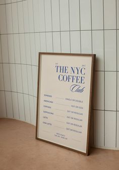 there is a sign that says the nyc coffee club next to a wall with white tiles