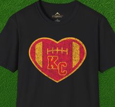 Enhance your fan gear collection with our Vintage KC Heart Red & Gold Kansas City Chiefs inspired t-shirt. Classic colors help you show your team spirit, and the distressed graphics give this shirt a vintage feel. It's ideal for pairing with your favorite jeans or leggings, or layering under a jacket for those colder game days. Plus, its high quality tubular construction means it will hold up, season after season, as you support your team through every touchdown and tackle. Team-colored Screen Print T-shirt For Fans, Crew Neck Sublimation Design With Team Logo For Fans, Fan Apparel Sublimation Design T-shirt, Red Pre-shrunk T-shirt For Fan Conventions, Retro Team Name T-shirt For Fans, Vintage T-shirt With Team Name For Fans, Retro T-shirt With Team Name For Fans, Football Season T-shirt With Graphic Print For Fan Events, Retro T-shirt With Team Name For Fan Gear