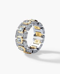 two tone gold and silver ring with cubics on the sides, set against a white background