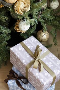 two wrapped presents sitting under a christmas tree