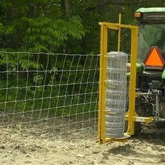 a tractor parked next to a fence in the dirt