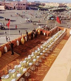 tables and chairs are set up in the middle of an open area with people walking around