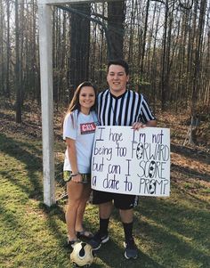 two people standing next to each other holding a sign