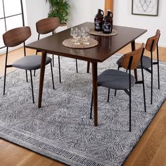 a dining room table with chairs and a rug on the floor