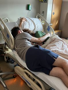 a man laying in a hospital bed next to a woman