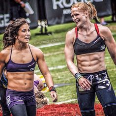 two women are walking on the field together