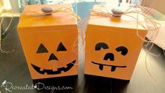 two pumpkin boxes with faces painted on them