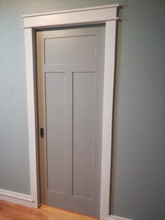 an empty room with a white door and hard wood floor