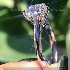 a close up of a person holding a ring with a diamond in it's center