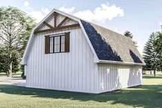 a small white barn with a black roof