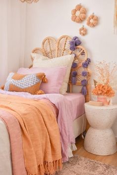 a bedroom with pink and orange decor on the walls, bedding and rugs