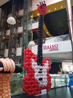 the balloon sculpture is made to look like a dog and has been placed in front of a building