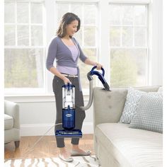 a woman is using a vacuum to clean the floor