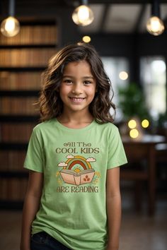 Kids Reader T-Shirt The kids heavy cotton tee is perfect for everyday use.  The fabric is 100% cotton for solid colors. Polyester is included for heather-color variants.  These fabrics are prime materials for printing.  The shoulders have twill tape for improved durability. The collar is curl resistant due to ribbed knitting.  There are no seams along the sides.  .: Material: 100% cotton (fiber content may vary for different colors) .: Midweight fabric (5.3 oz/yd² (180 g/m .: Classic fit .: Tear-away label .: Runs true to size SIZING: Runs true to size, but please refer to size chart, to order according to your exact measurements. Sweatshirt https://moonlitwonderland.etsy.com/listing/1614431226 Sweatshirt https://moonlitwonderland.etsy.com/listing/1582559870 Sweatshirt https://moonlitwonde Kids Reading, Kids Tops, The Cool, Twill Tape, Color Choices, Cotton Fiber, Cool Kids, Color Matching, Different Styles