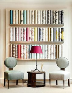 two chairs sitting in front of a book shelf filled with books