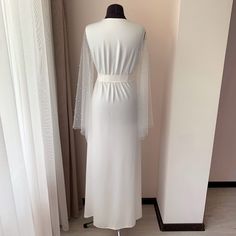 "A long bridal robe with pearls on the sleeves for lovers of sophisticated, unusual beauty. This is a great combination of uncompromising luxury and absolute comfort. Thanks to the belt that comes with the kit and the V-neck, graceful folds of fabric stretch the silhouette and you will look noticeably slimmer🤗. The same only short : https://www.etsy.com/listing/841980863/bridal-robe-with-pearls-wedding-kimono?col=1 Made in Ivory will be the perfect outfit for the bride and in the future will be Wedding Kimono Robe, White Bridal Robe, Long Bridal Robe, Bride Dressing Gown, Unusual Beauty, Boho Maternity Dress, Bridal Nightgown, Robe Wedding, Lace Bridal Robe