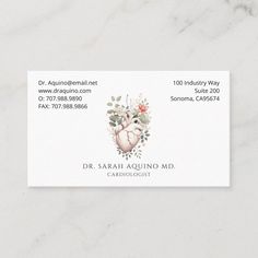 a business card with an image of a heart and flowers on the front, in white marble