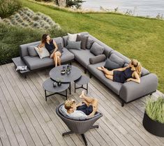 two women laying on couches in the middle of a deck