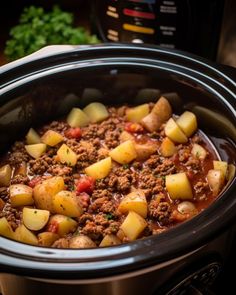 a crock pot filled with meat and potatoes