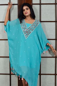 Turquoise asymmetrical tunic with mirror work and thread embroidery. Comes with slip.
Components:2
Pattern:Embroidered
Type of Work:Mirror and Thread
Neckline:V neck
Sleeve Length:Flared Sleeves
Fabric:Georgette and Shantoon
Color:Blue
Other Details:
Tassels on the hem
Occasion:Resort - Aza Fashions Anarkali Tunic Dress With Mirror Work, Bollywood Style Designer Tunic Dress, Embellished Georgette Kurta For Summer, Bollywood Tunic Dress With Mirror Work, Designer Tunic Kurta For Summer, Eid Tunic Dress With Mirror Work, Summer Blue Kurta With Dupatta, Blue Summer Kurta With Dupatta, Bollywood Style Embellished Tunic Dress