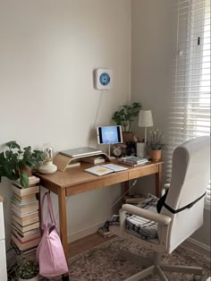 a desk with a chair, computer and books on it