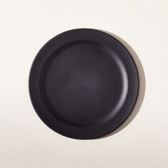 a black plate sitting on top of a white table