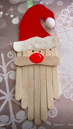 popsicle santa claus ornament with red nose and white beard on brown background