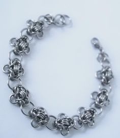 A stunning hand made chain bracelet using a chainmaille weaving technique out of stainless steel jump rings.  Stainless steel is a fully hypoallergenic and anti tarnish metal, perfect for sensitive skin and is very hard-wearing.  Each bracelet is made to order by hand, the bracelets can be made to any size so please feel free to leave your measurements in the order notes if you know them.  If you don't know your measurements the bracelets are made to a standard size of 6.5-7 inches but are fully Flower Chain Bracelet, Flower Chain, Chunky Bracelet, Bracelet Minimalist, Chunky Bracelets, Minimalist Bracelet, Bead Stringing, Bracelet Silver, Weaving Techniques