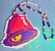 Taco Bell logo bell in classic colors. Pony bead necklace is made with nylon string and an easy-open clasp, so no need to pull the whole necklace over your head or braids! "Tinkle Outside the Binkle" is a throwback to a classic Tumblr meme. Melty Beads Necklace, Festival Perler, Pony Bead Patterns Easy, Kandi Necklaces, Pony Bead Necklace, Perler Bead Necklace, Perler Necklaces, Taco Bell Logo, Rave Kandi Ideas