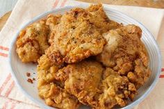 some fried food is on a plate with a napkin next to it and a glass of water