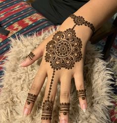 a woman's hand with henna tattoos on it