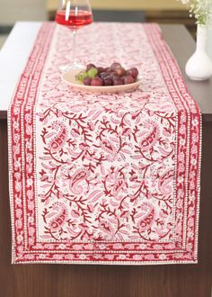 a table topped with a plate of grapes next to a glass of wine