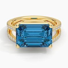 Revelry London Blue Topaz and Diamond Cocktail Ring - 18K Yellow Gold. A dramatic emerald-cut London blue topaz takes center stage in a unique split shank design adorned with shimmering diamonds in this modern cocktail ring. As festive as it is contemporary, this romantic hues-of-blue design is sure to catch the light and the eye (2/5 total carat weight). Diamond Cocktail Rings Unique, Cocktail Ring Designs, Ring Style Guide, Cut Rings, Modern Cocktail, Emerald Wedding Rings, Trending Engagement Rings, Heart Engagement Rings, Diamond Cocktail Ring