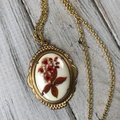 Orange and olive retro floral cameo neckace in brass setting on gold tone chain with spring ring cla Retro Gold Flower Jewelry, Handmade Vintage Resin Jewelry, Vintage Oval Brass Necklace, Vintage Gold Resin Jewelry, Vintage Brass Necklace With Oval Pendant, Vintage Flower-shaped Nickel-free Necklaces, Vintage Flower Necklaces With Pressed Flowers, Vintage Brass Oval Pendant Necklace, Vintage Flower Necklace With Pressed Flowers