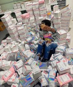 a woman sitting on top of a pile of boxes