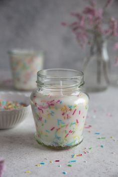 a glass jar filled with sprinkles next to a bowl