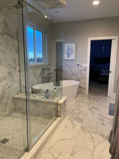 a bathroom with marble walls and flooring next to a bathtub in the corner