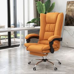 an orange reclining chair sitting on top of a hard wood floor next to a plant