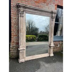 a large mirror sitting next to a brick building