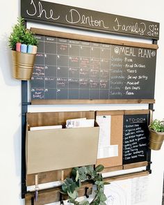 a blackboard with writing on it next to potted plants and other office supplies