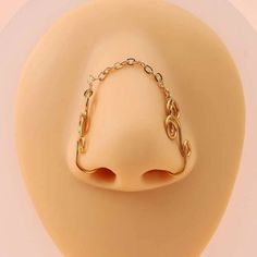 a gold chain ring on top of a white mannequin's dummy head