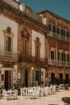 an old building with tables and chairs outside