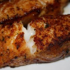 two pieces of meat sitting on top of a white plate